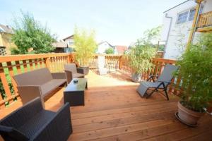 Un patio con sillas y mesas en una terraza de madera. en WerkLoft Neckarsulm, en Neckarsulm