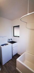 een kleine keuken met een wastafel en een witte koelkast bij The Barnyard Cottage in Otakiri