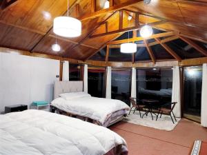 a bedroom with two beds and a table and chairs at Los uros Domo Atardecer in Puno +14 photos