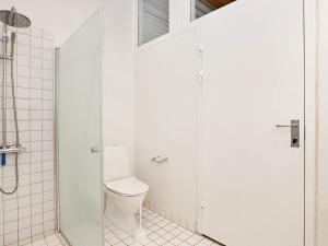 Un baño blanco con inodoro y ducha. en 6 person holiday home on a holiday park in Sæby, en Saeby