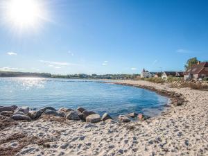 une plage de sable avec des rochers dans l'eau dans l'établissement 4 person holiday home on a holiday park in Hejls, à Hejls 79 autres photos
