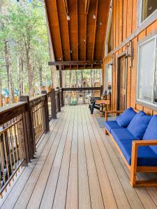 a porch of a house with a blue couch at Moki Pines Chalet - Stylish Stay Among the Pines in Flagstaff