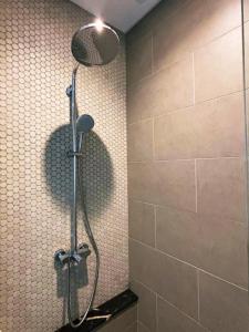 a shower with a shower head in a bathroom at Lucentia Suites klcc by SkyPool in Kuala Lumpur