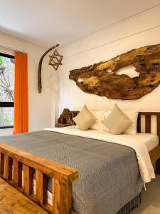 a bedroom with a large bed with a wooden bench at Gallery House - Artistic Villa with Plunge Pool in Phumĭ Réach Born (1)