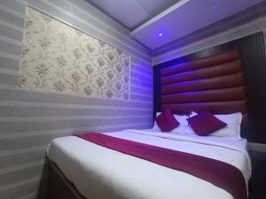 a bedroom with a large bed with purple lighting at Hotel Shimla Inn in Lucknow