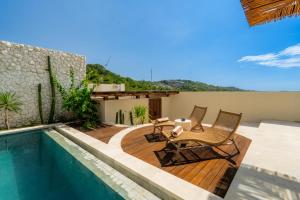 a patio with two chairs and a swimming pool at Villa Cove 5 by BaliSuperHost in Uluwatu +19 photos