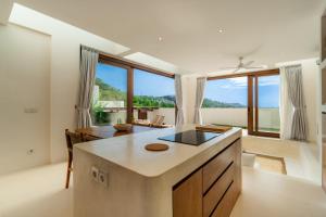 a kitchen with white walls and a large window at Villa Cove 5 by BaliSuperHost in Uluwatu