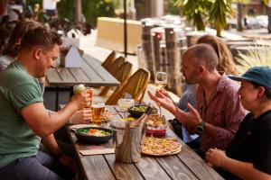 eine Gruppe von Menschen sitzt um einen Tisch herum und isst in der Unterkunft The Australian Heritage Hotel in Sydney