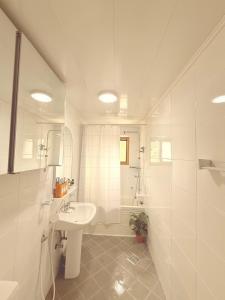 a white bathroom with a sink and a tub at 온유재스테이 N seoul tower 800m in Seoul