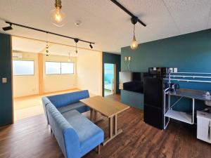 un soggiorno con un divano blu e un tavolo di Petit villa Sea grapes a Nago