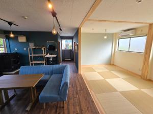 un soggiorno con un divano blu e un tavolo di Petit villa Sea grapes a Nago