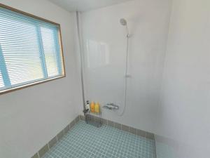 un bagno bianco con doccia e pavimento in piastrelle blu di Petit villa Sea grapes a Nago Altre 23 foto