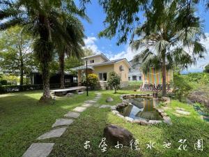 een huis met een vijver in de tuin bij Annongriver B&B in Sanxing