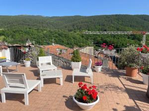 アッセルジにあるLarge familyの花が咲くパティオに置かれた白い椅子のグループ