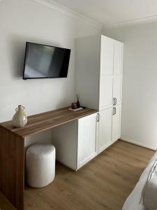 a bedroom with a desk with a tv on the wall at Hillview Studio One in Berry +1 photo