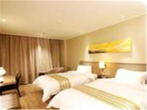 a hotel room with two beds and a desk at Home Inn Ji'Nan Jiefang Road in Jinan