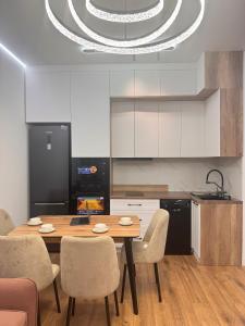 a kitchen with a wooden table and chairs in a room at Аппартамент в Астане in Astana