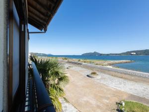 Una vista de la playa desde un balcón de un edificio. en Kurosakisou, en Miyazu