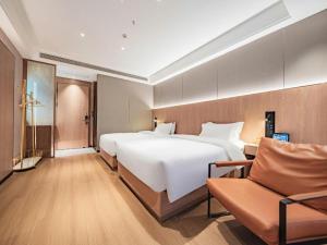 ein Hotelzimmer mit einem großen Bett und einer Couch in der Unterkunft James Joyce Coffetel Xi'an Laochenggen Hongmiaopo Metro Station in Xi'an + 240 Fotos