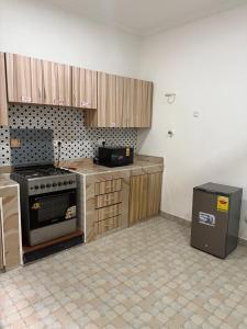 een keuken met houten kasten en een fornuis bij Groove Vacation Homes in Kasoa