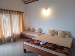 une chambre avec deux lits et un canapé dans l'établissement Solitary Cottage Dunhinna, à Teldeniya