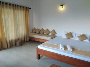 une chambre avec deux lits et un canapé dans l'établissement Solitary Cottage Dunhinna, à Teldeniya