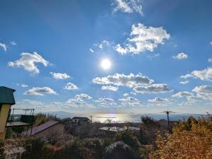 伊东SAKURA Cottage Izukogen的蓝天白云，太阳高悬