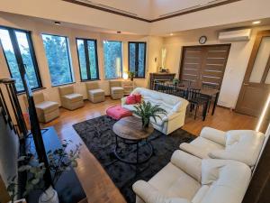 uma sala de estar com dois sofás brancos e uma mesa em SAKURA Cottage Izukogen em Ito mais 86 fotografias