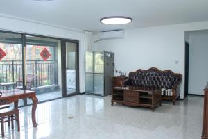een woonkamer met een bank en een tafel bij Ivy Residence in Jiaozhou
