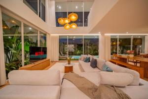 un salon avec des canapés blancs et une table dans l'établissement Luxury 3BR Seseh Villa Ocean View with Rooftop Lounge & Beach Access, à Cemagi