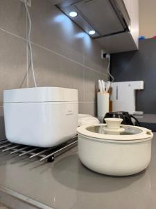 a kitchen counter with a white appliance on a counter top at StayCO - D'Millenia Residences - Studio Unit in Kuching