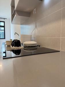 a kitchen with a black counter top in a room at StayCO - D'Millenia Residences - Studio Unit in Kuching +8 photos