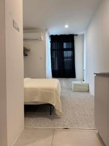 a bedroom with a bed and a window at StayCO - D'Millenia Residences - Studio Unit in Kuching