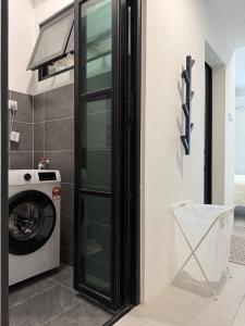 a laundry room with a washer and dryer at StayCO - D'Millenia Residences - Studio Unit in Kuching