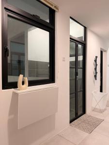 古晋StayCO - D'Millenia Residences - Studio Unit的一间房间,在架子上设有窗户,带花瓶