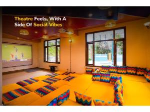 a room with a large room with couches and a screen at goSTOPS Mukteshwar in Mukteswar