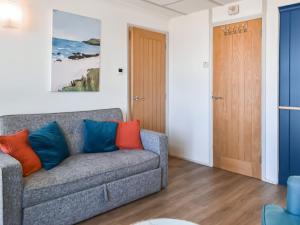 ein Wohnzimmer mit einem Sofa und einer Holztür in der Unterkunft Little Palms in Bude