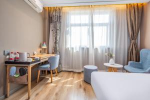 a room with a desk and chairs and a window at Home Inn Yuncheng Yuxi Road Yudu in Yuncheng