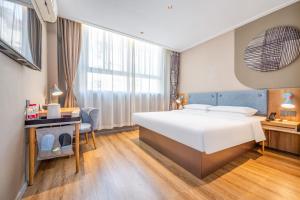 a hotel room with a large bed and a desk and a desk at Home Inn Yuncheng Yuxi Road Yudu in Yuncheng