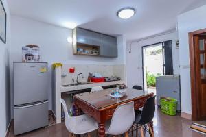 eine Küche mit Tisch und Stühlen und einem Kühlschrank in der Unterkunft Angkor Nesthouse in Siem Reap