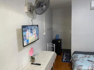 a room with a bed and a tv on the wall at Ban Pak Khun Taa in Khon Kaen