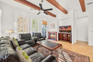 a living room with a couch and a tv at LV305 Legacy Villas Townhome w Expansive Patio in La Quinta