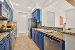a kitchen with blue cabinets and a stainless steel refrigerator at LV305 Legacy Villas Townhome w Expansive Patio in La Quinta +39 photos