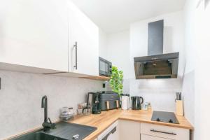 a kitchen with white cabinets and a counter top at Hotel Essen mit Apartments in Essen