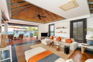 ein Wohnzimmer mit einem Deckenventilator und einem Sofa in der Unterkunft Luxury villa Seaview & Sunset 100m from the beach in Ko Phangan