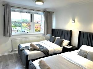 une chambre avec deux lits et une fenêtre dans l'établissement Ama comfort Stay, à Hythe