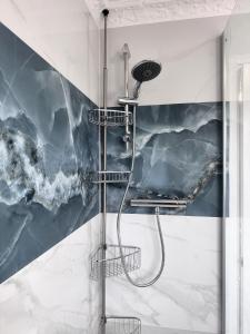 La salle de bains est pourvue d'une douche et d'un mur en marbre. dans l'établissement Ama comfort Stay, à Hythe 42 autres photos