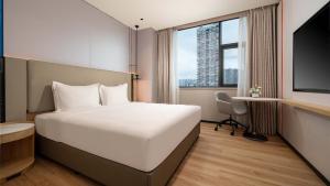 een hotelkamer met een bed en een groot raam bij Holiday Inn Express Ziyang City Center by IHG in Ziyang