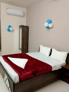 a bedroom with a large bed with a red blanket at hotel shreejee in Himatnagar