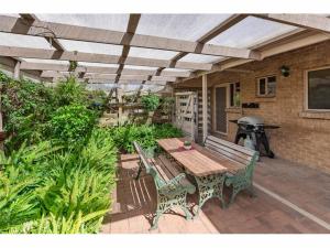 a patio with a wooden table and chairs and a grill at River Murray Views in Nildottie